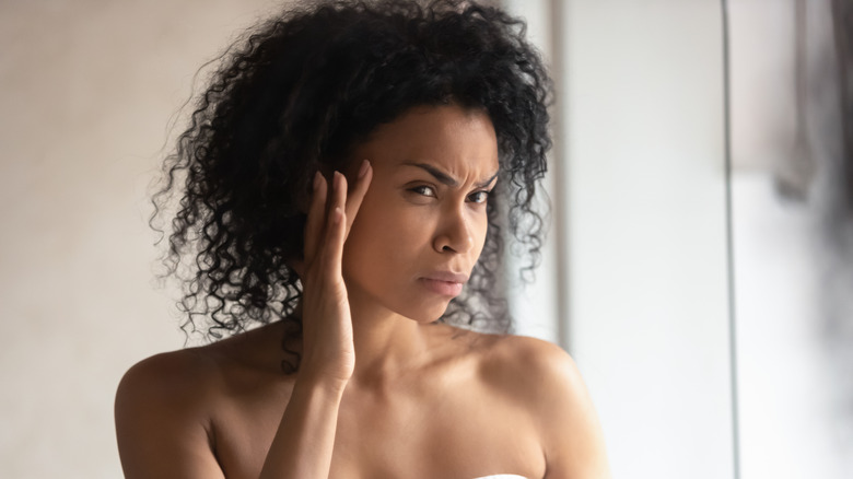 woman looking in mirror worried