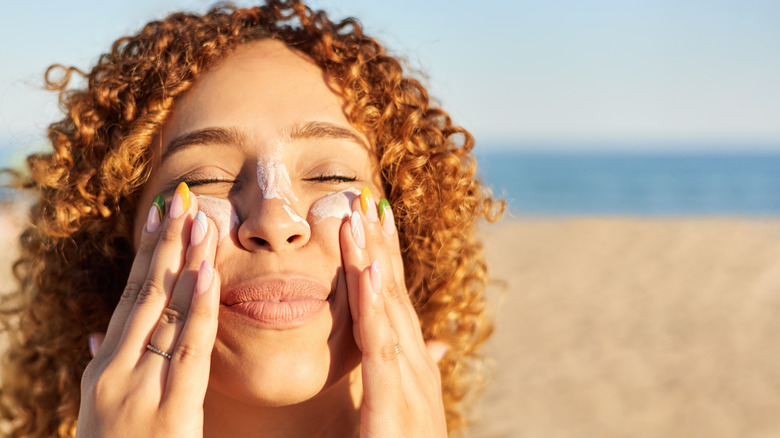 A woman applying sunscreen