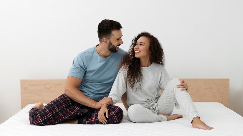 Happy couple sitting on bed