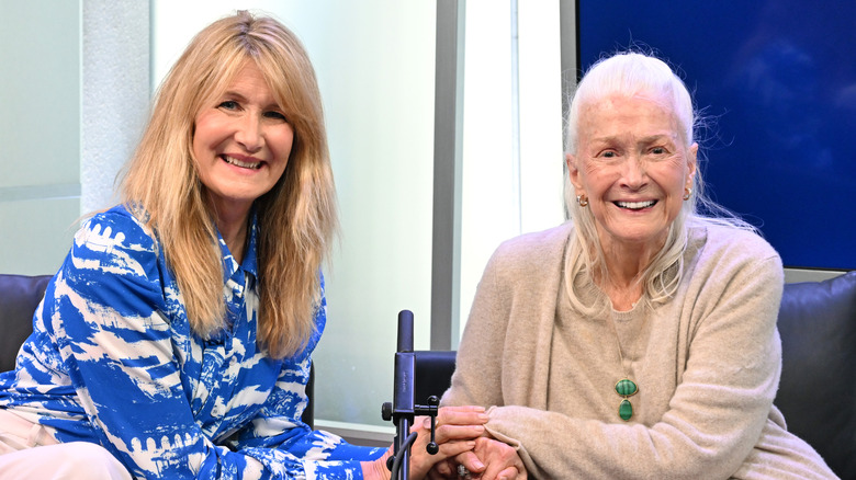 Laura Dern reaches over to hold her mother Diane Ladd's hand while they sit together in a recording studio
