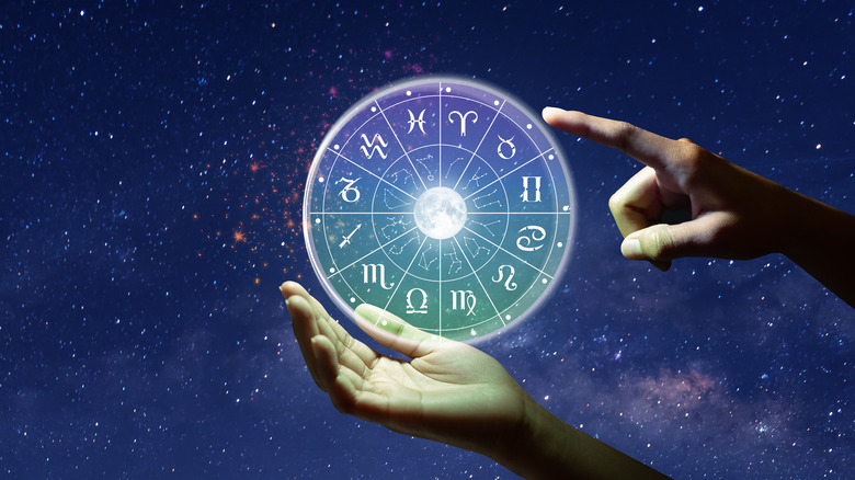 hand holding zodiac wheel