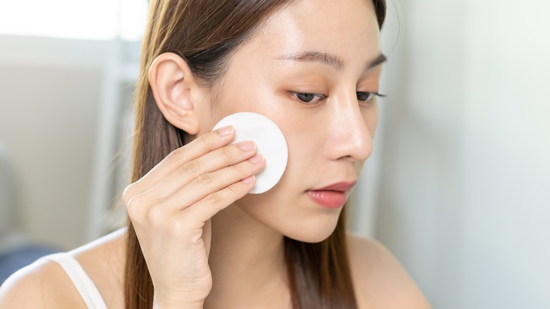 Woman removing makeup with a wipe