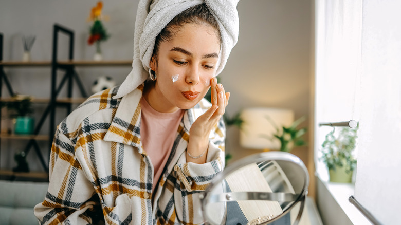Woman using face moisturizer