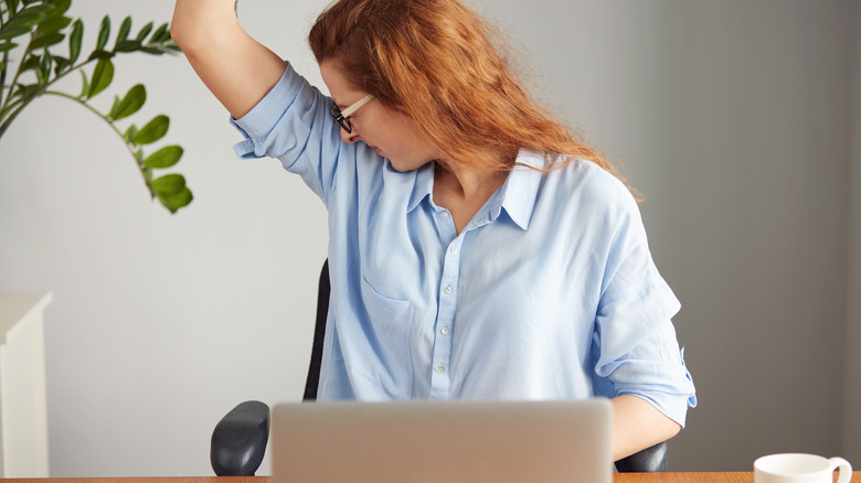 woman sniffing her armpit