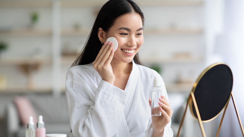 woman using cotton pad on face