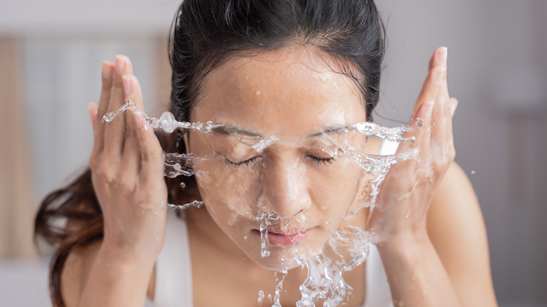 Woman splashes water on face 