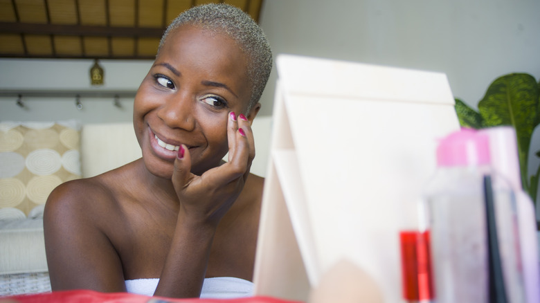 Woman applies primer to face