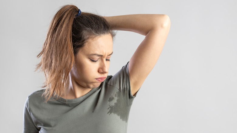 Woman examining underarm sweat