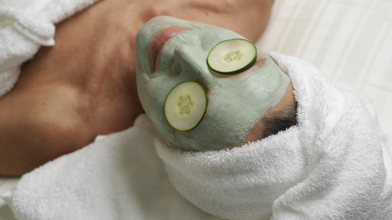 woman laying down with green face mask
