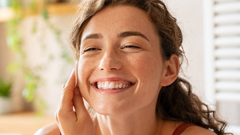 Woman smiling taking off her makeup