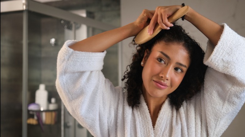 A woman brushing her curly hair