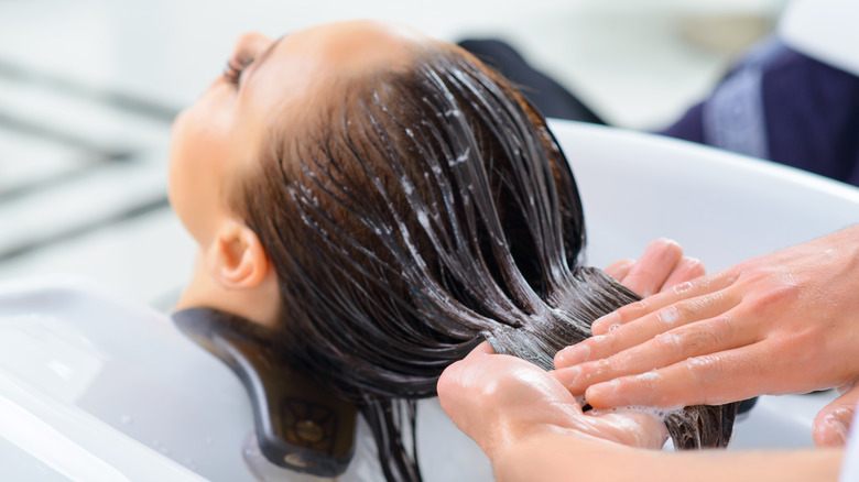 Woman receiving hair treatment