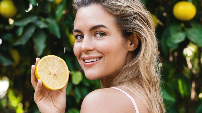 Woman with radiant skin holding lemon