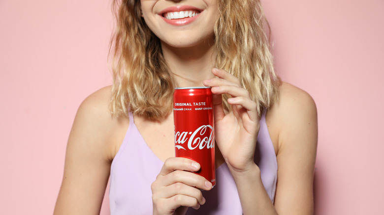 Happy woman holding Coca-Cola can