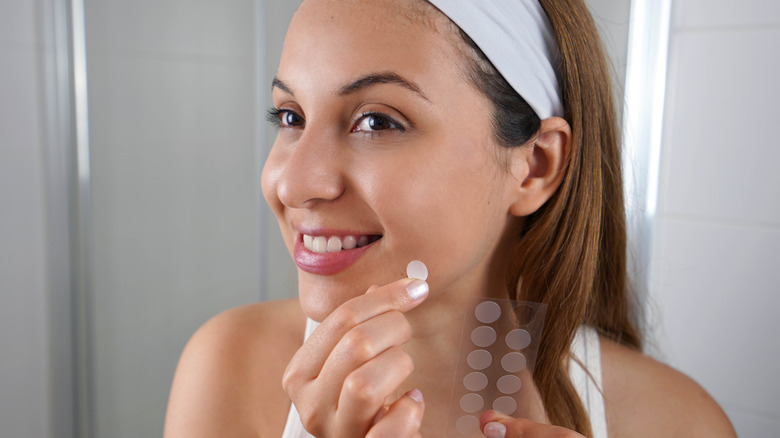 woman applying pimple patch