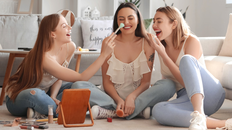 Women doing their makeup together.