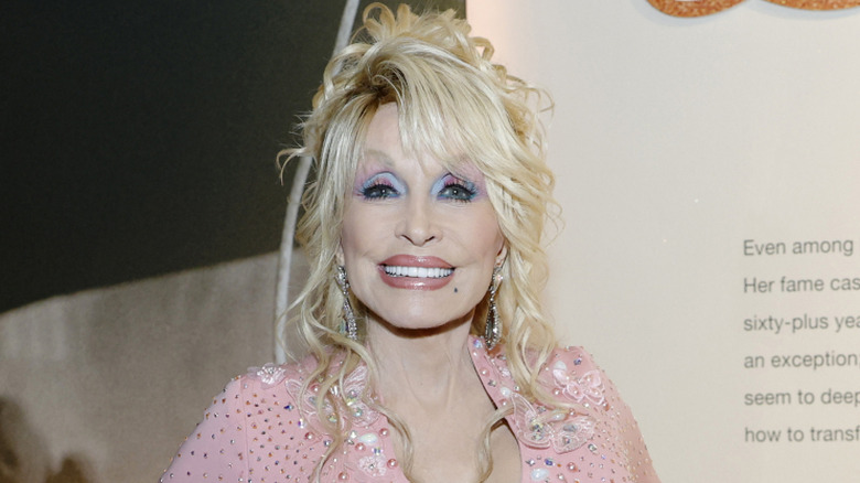 Dolly Parton stands and smiles at a country music event
