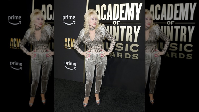 Dolly Parton attends the 2023 Academy of Country Music Awards wearing a silver jeweled top and pants set