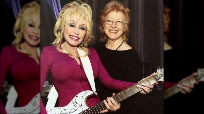 Dolly Parton (left) with Judy Ogle (right) wearing glasses and a black T-shirt