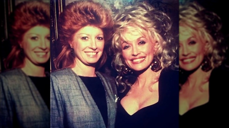 Dolly Parton (right) with Judy Ogle (left) who is wearing a grey blazer and an ultra-teased hairstyle