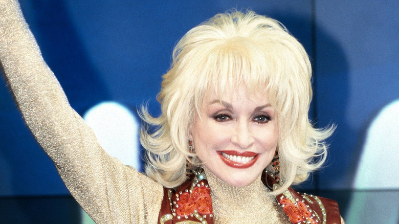 Dolly Parton wearing a brown waistcoast and a bob hairstyle