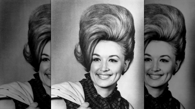 A black and white photo of Dolly Parton wearing a huge combover wig