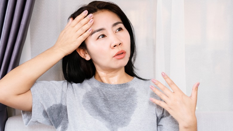 Woman sweating in a gray shirt.