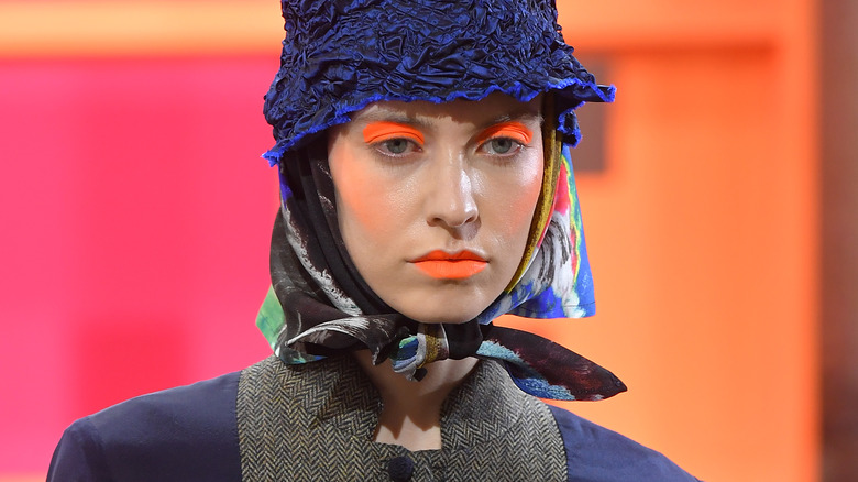 model wearing orange eyeshadow and lipstick