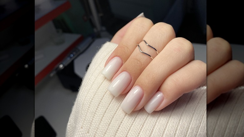 A woman's hand with a coconut milk manicure