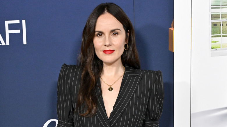 Michelle Dockery wears a black pinstriped blazer and red lipstick