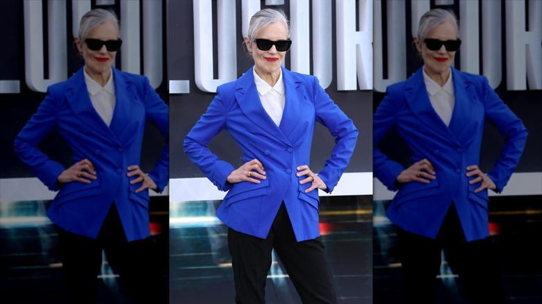 Elizabeth McGovern poses wearing black sunglasses and a bright blue blazer