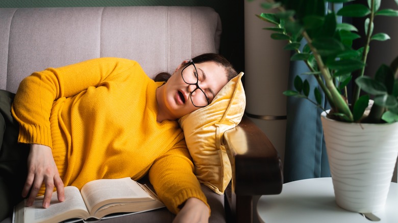 Woman sleeps holding book