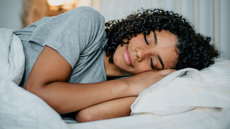 woman happily sleeping in bed
