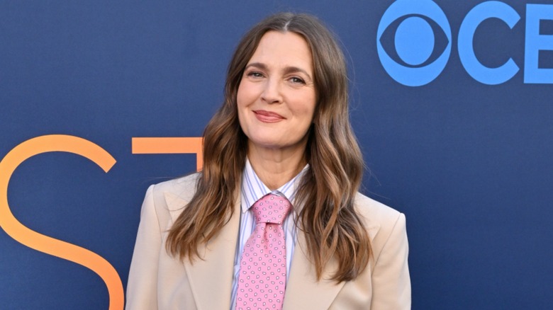 Drew Barrymore at the CBS Fest in Los Angeles in 2025 wearing a beige suit with a pink tie.
