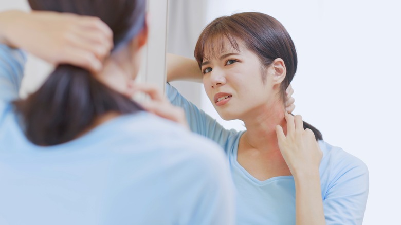 woman looking at her neck