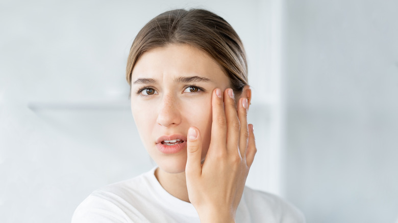 woman inspecting eye in mirror