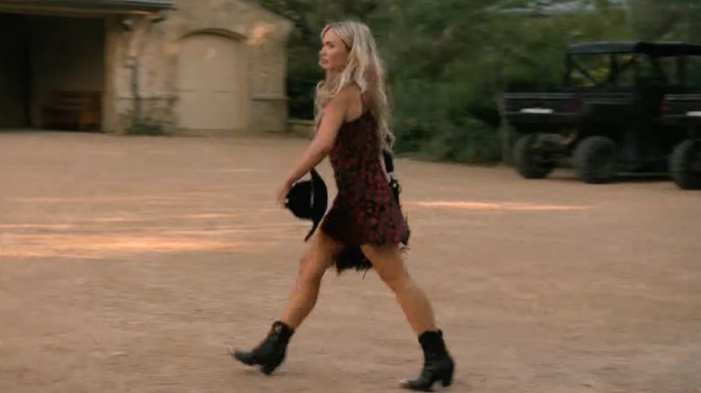 Oreana Jackson walks wearing a floral minidress and cowboy boots in a scene from "Dutton Ranch."