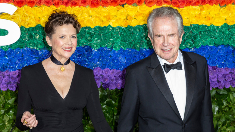 Annette Bening and Warren Beatty in front of a rainbow flower wall