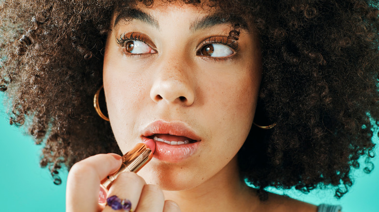 Woman applying lipstick