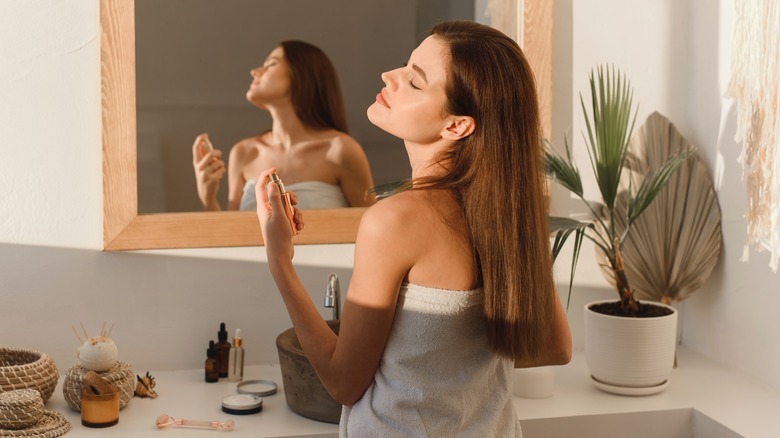 woman using perfume in towel