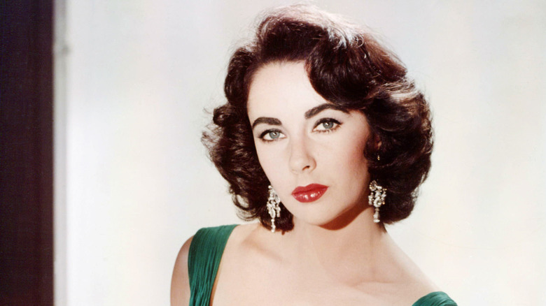 Elizabeth Taylor wearing red lipstick, eyeliner, and bold eyebrows