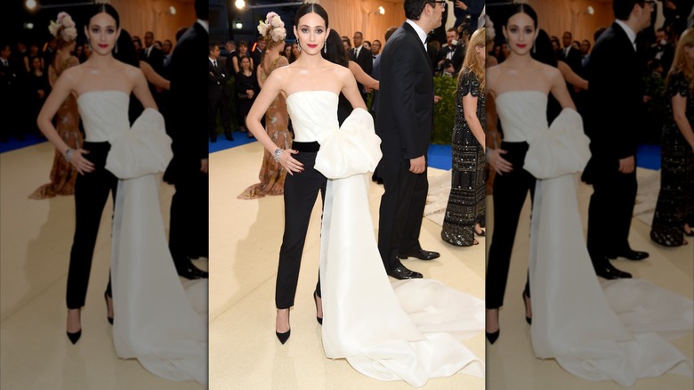 Emmy Rossum attends the 2017 Met Gala in black tailored pants and a white strapless top with a train