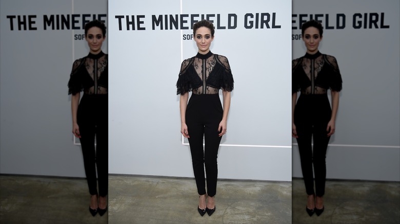 Emmy Rossum wears a black jumpsuit and pointed-toe heels