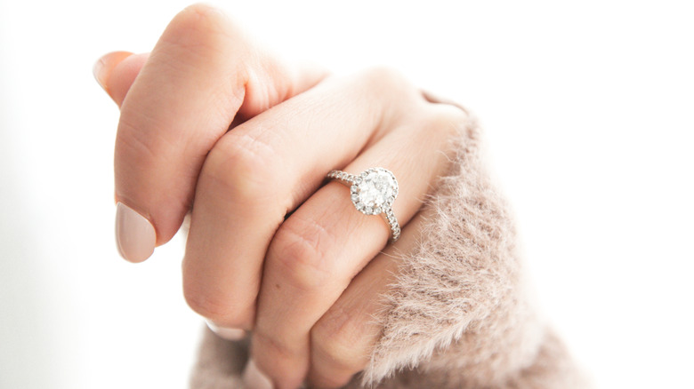 A woman wearing a pavé engagement ring which is one ring style people may regret