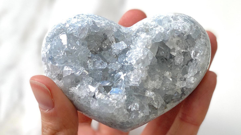 person holding celestite crystal 