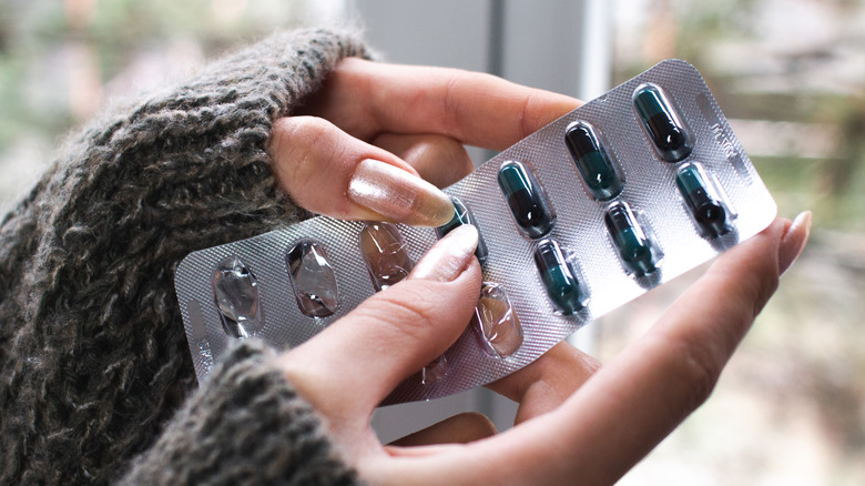 woman holding doxycycline acne pills