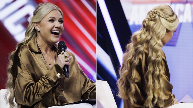 Erika Kirk laughs while speaking into a microphone and sitting on stage