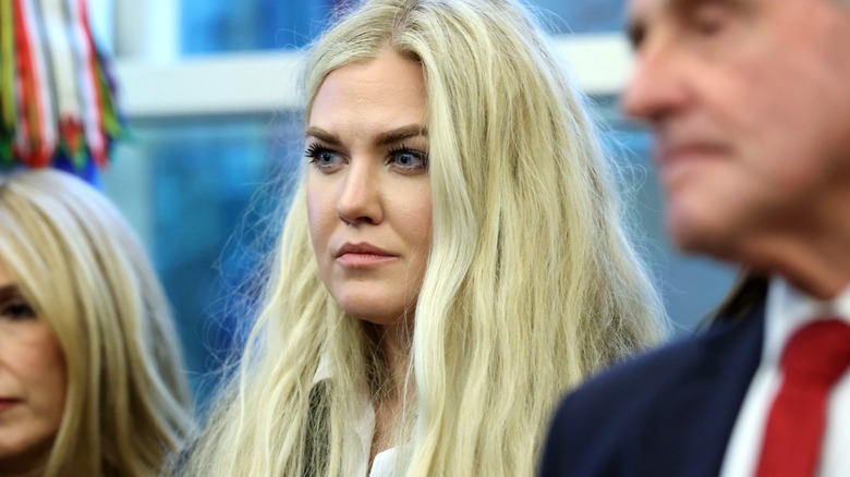 Erika Kirk in the White House. Her blonde extensions are extremely thick and long, and her makeup is overly done - she has drawn-on dark brown eyebrows, and heavy foundation.