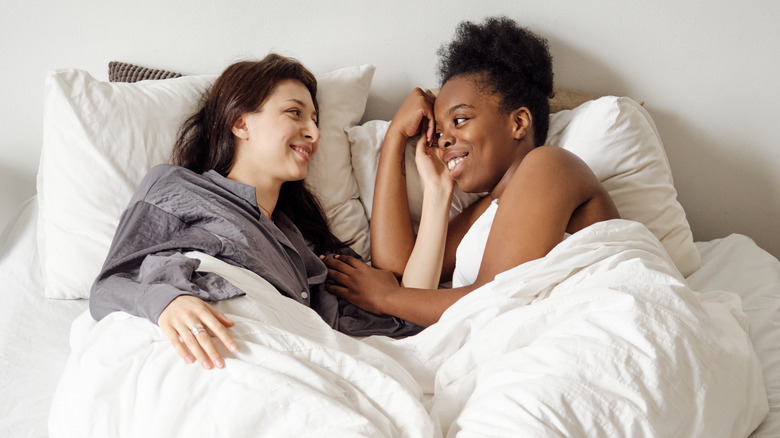 two smiling women in bed