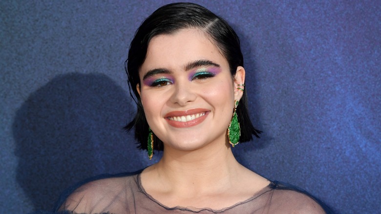 Barbie Ferreira at the Euphoria 2019 premiere. She is a young woman with fair skin and short black hair. She is wearing purple and green shimmery eyeshadow.